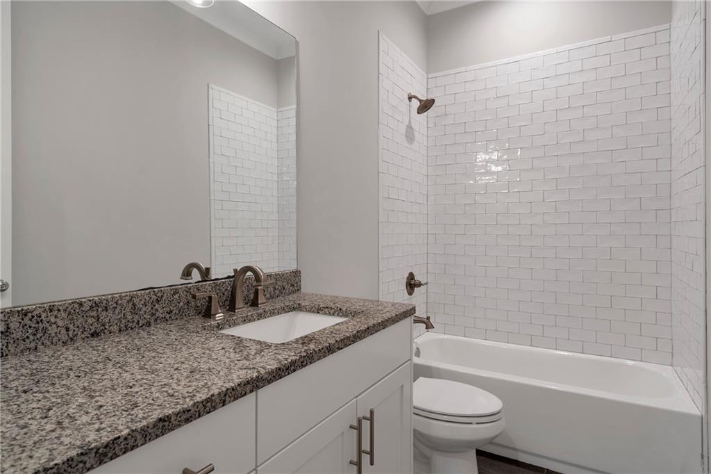 254 Fortress Way Jefferson, GA 30549 - Photo 52 of 69 a bathroom with a granite countertop sink a toilet and bathtub