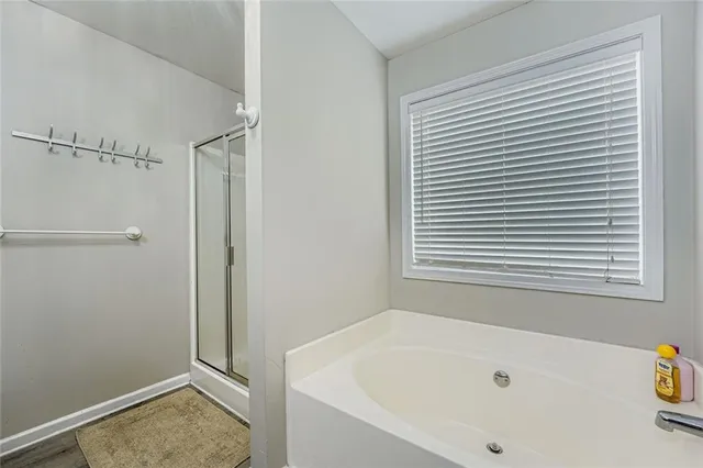 a bathroom with a tub shower and a window