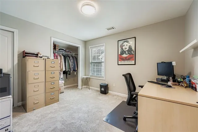 a view of a workspace with furniture and a window