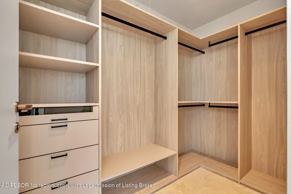 a view of walk in closet with empty racks