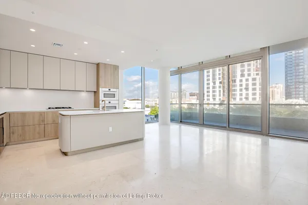 a large kitchen with stainless steel appliances granite countertop a large counter top a stove and a refrigerator