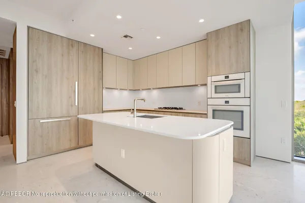 a kitchen with kitchen island a sink stainless steel appliances and cabinets