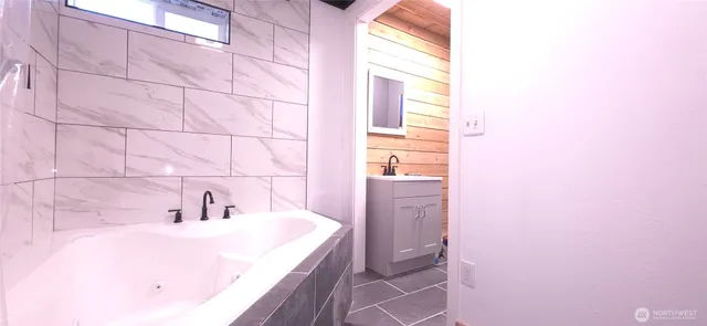 a bathroom with a sink a bathtub and a window
