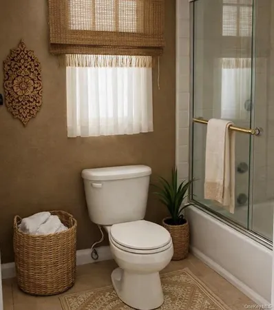 a bathroom with a toilet a window and shower