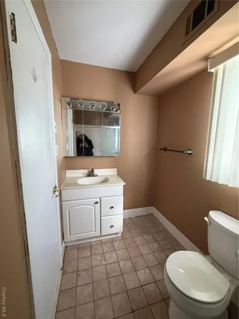 a bathroom with a sink toilet and window