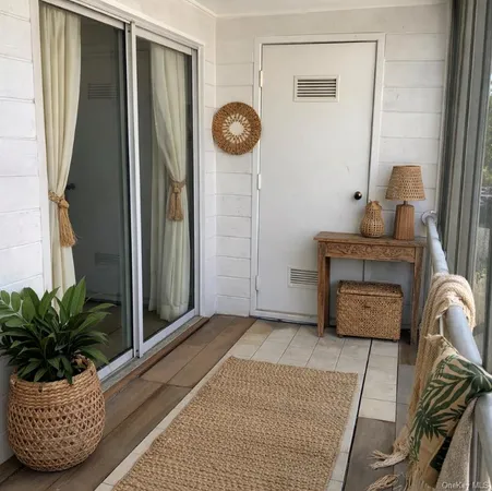 a view of hallway with furniture and a potted plant