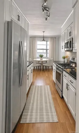 a kitchen with granite countertop a refrigerator stove and sink