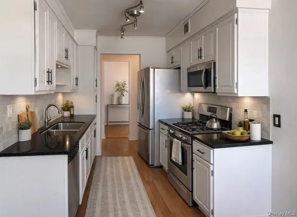 a kitchen with stainless steel appliances a sink stove and refrigerator