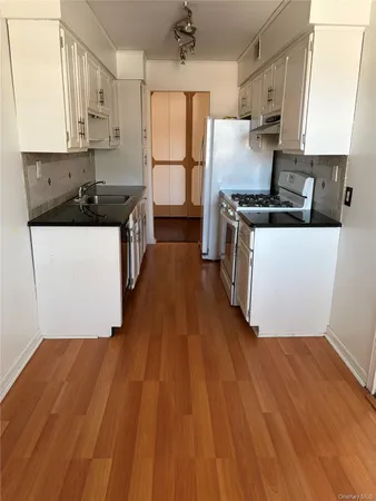 a kitchen with wooden floors and white appliances