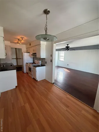 a kitchen with stainless steel appliances granite countertop a refrigerator a stove and a wooden floors