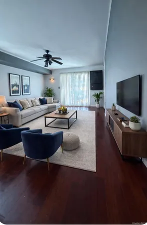 a living room with furniture flat screen tv and window