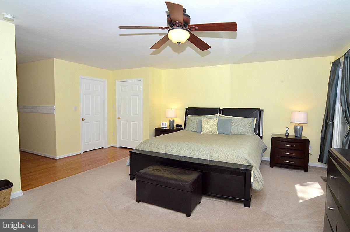7900 Bennett Branch Road Mount Airy, MD 21771 - Photo 16 of 30 a bedroom with a bed and a chandelier