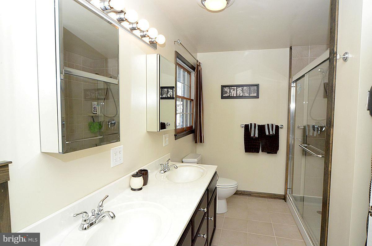 7900 Bennett Branch Road Mount Airy, MD 21771 - Photo 18 of 30 a bathroom with a sink shower and a mirror