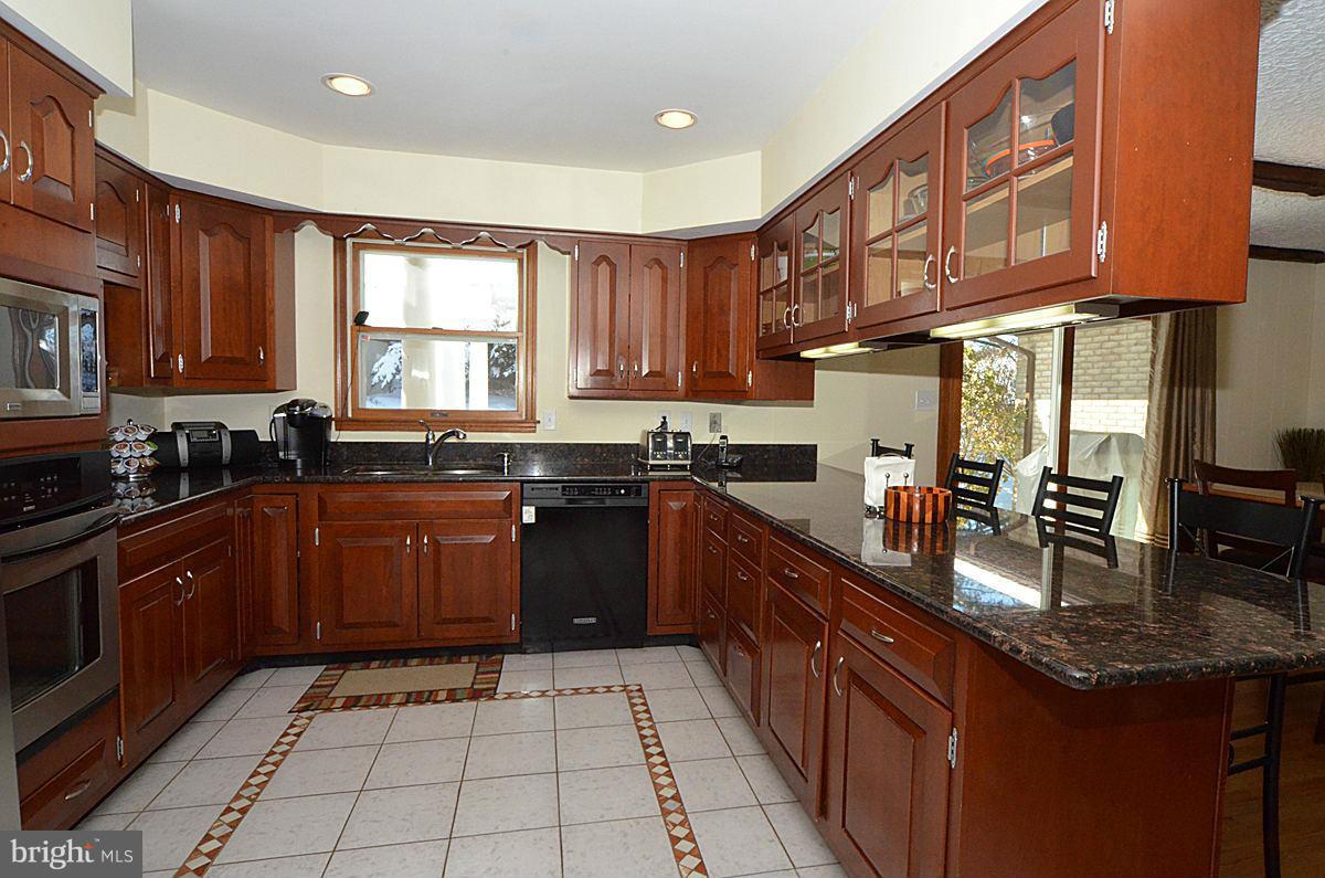 7900 Bennett Branch Road Mount Airy, MD 21771 - Photo 4 of 30 a kitchen with granite countertop a stove sink and cabinets