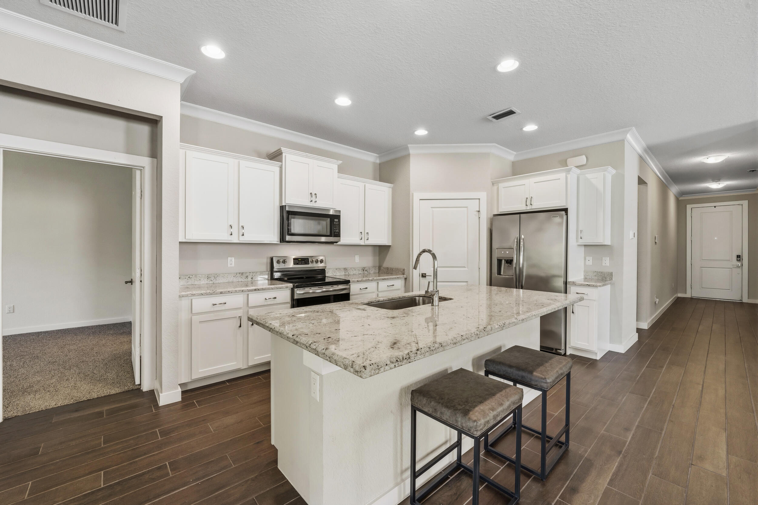7461 Southwest Harbor Cove Drive Stuart, FL 34997 - Photo 12 of 30 a kitchen with a refrigerator a stove top oven a sink dishwasher and wooden floor