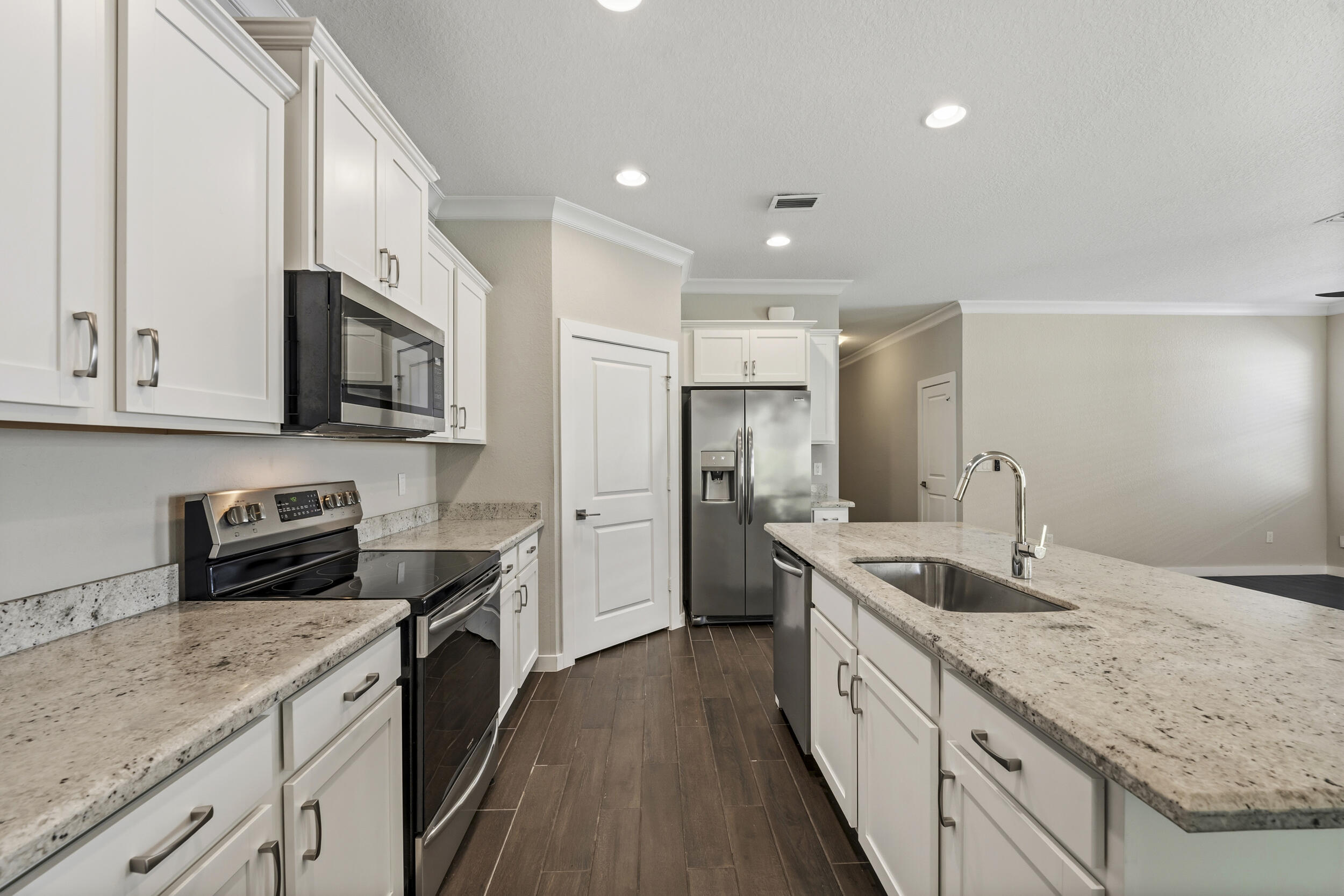 7461 Southwest Harbor Cove Drive Stuart, FL 34997 - Photo 13 of 30 a kitchen with stainless steel appliances granite countertop a sink stove and refrigerator