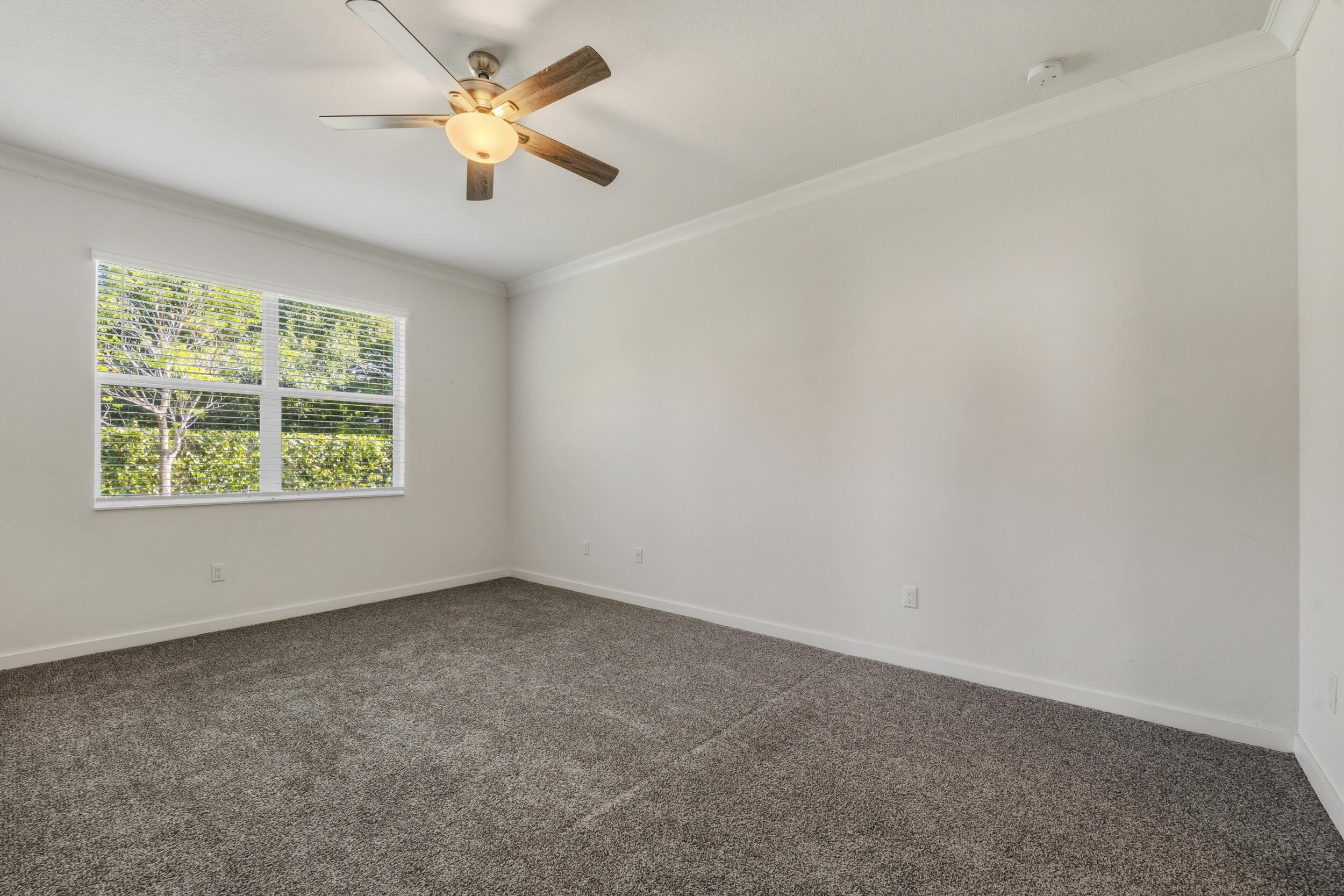 7461 Southwest Harbor Cove Drive Stuart, FL 34997 - Photo 18 of 30 an empty room with a window and a fan
