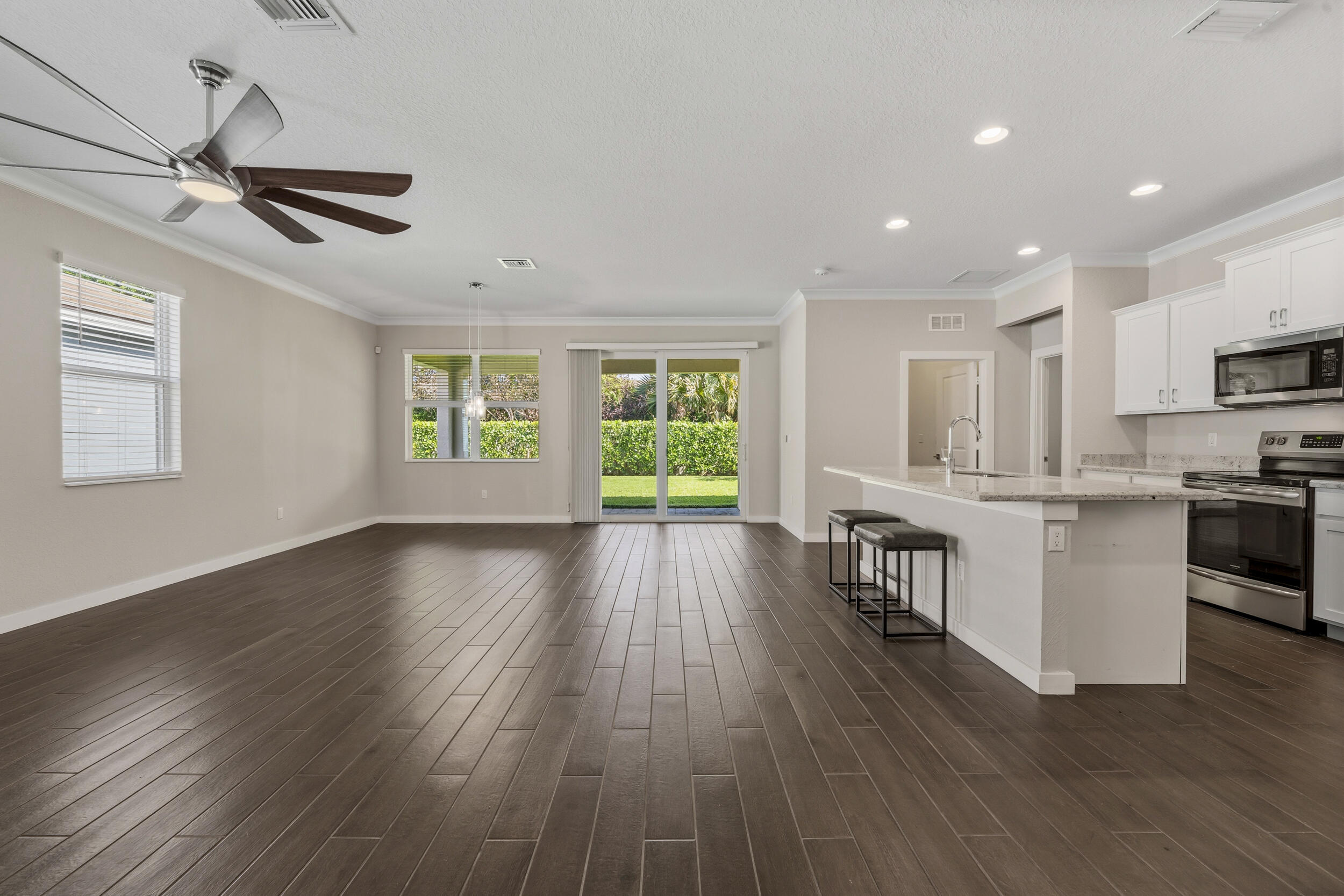 7461 Southwest Harbor Cove Drive Stuart, FL 34997 - Photo 9 of 30 a view of a kitchen with wooden floor a sink a refrigerator and window
