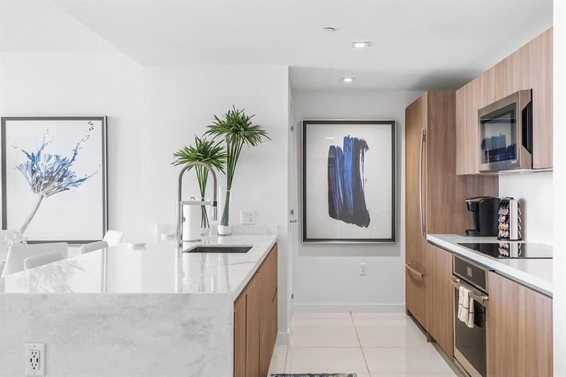 401 North Birch Road, Unit 1214 Fort Lauderdale, FL 33304 - Photo 8 of 47 a kitchen with stainless steel appliances granite countertop a refrigerator and a stove