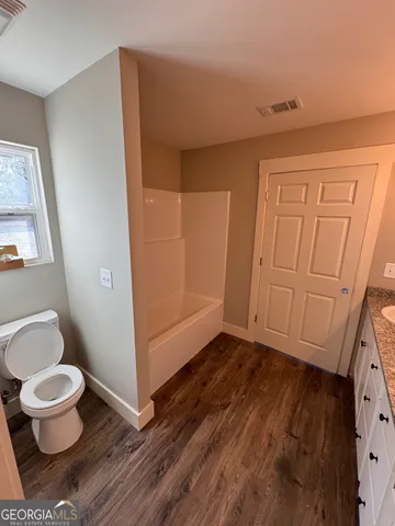 a bathroom with a toilet and a shower