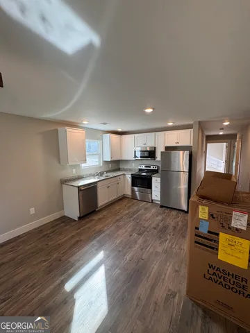 a large kitchen with stainless steel appliances granite countertop a refrigerator and a stove top oven