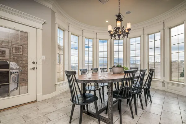 a view of a dining room with furniture and large windows
