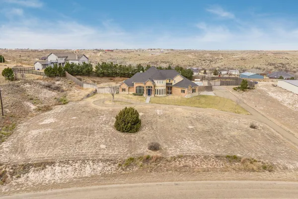 an aerial view of a house with a yard and lake view