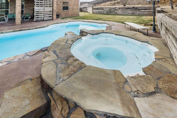 a view of a swimming pool with a yard and sitting space