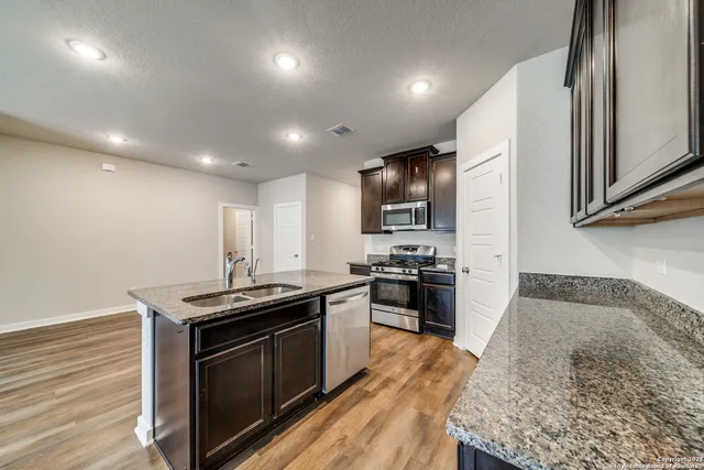 a kitchen that has a sink a stove and a microwave