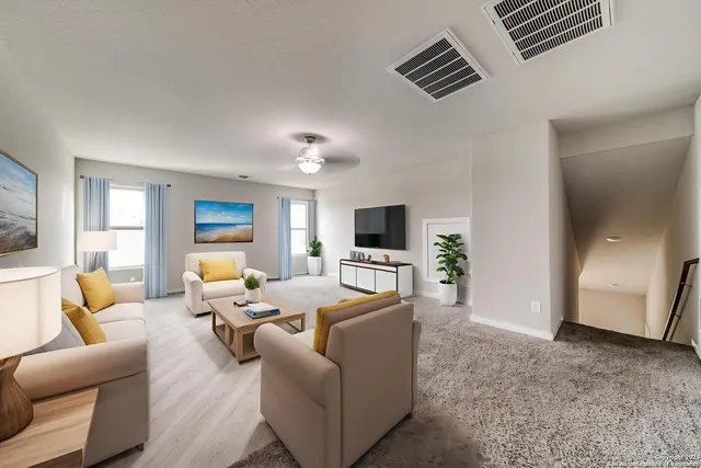 a view of an empty room with a chandelier fan