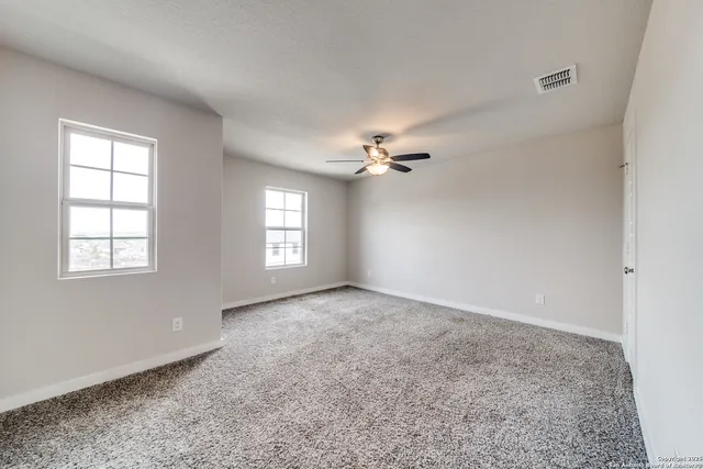 a view of an empty room with a ceiling fan