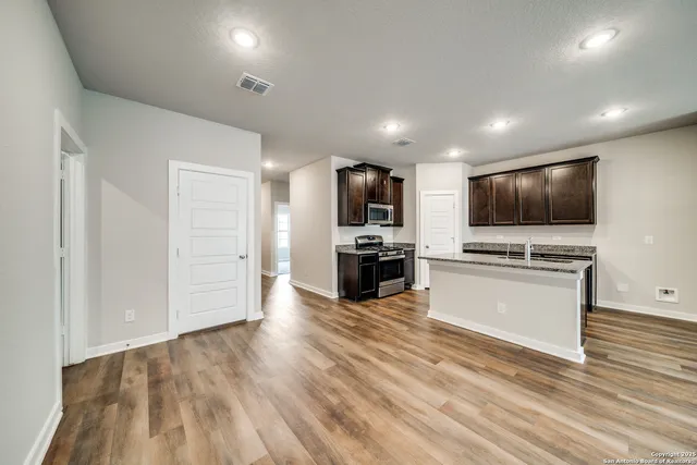 a kitchen with stainless steel appliances granite countertop a stove a sink and a refrigerator