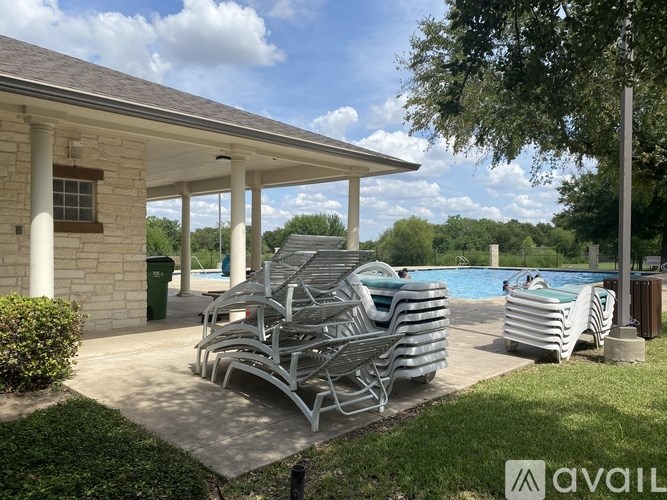 2120 Jester Farms Road Round Rock, TX 78664 - Photo 27 of 28 A well-maintained community pool awaits, featuring a covered lounge area and verdant landscaping.