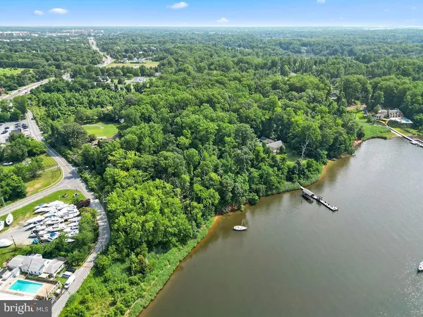 an aerial view of a houses with a yard and lake view