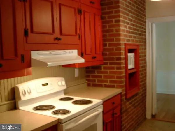 a view of empty room with wooden floor and fireplace