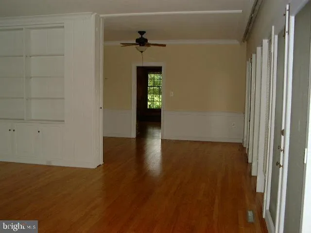 a view of empty room with wooden floor and fireplace