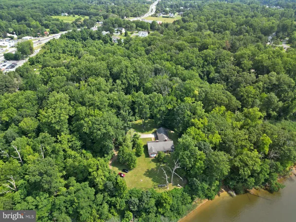 an aerial view of a houses with a yard and lake view