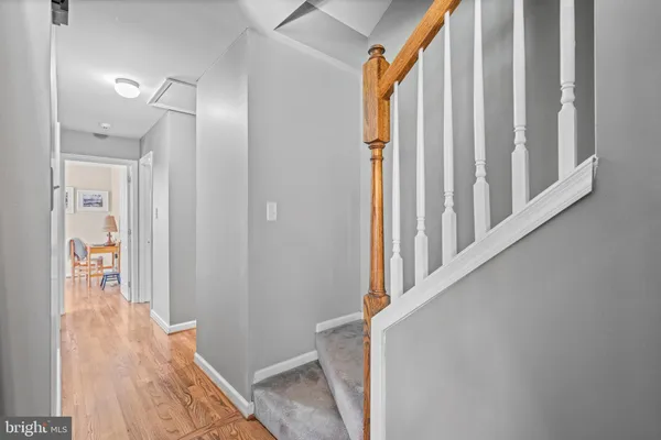 a view of a hallway with wooden floor and staircase