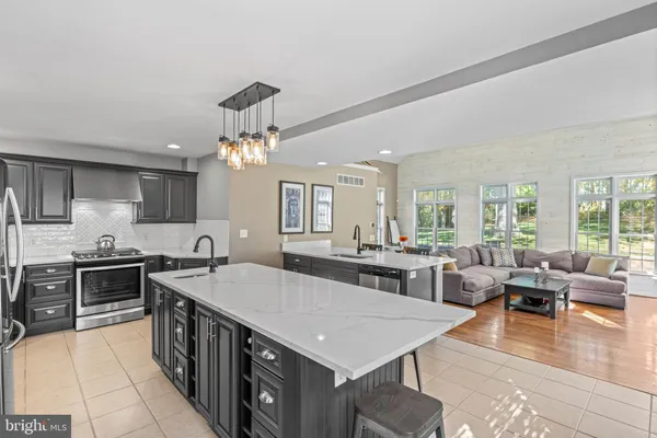 a large kitchen with kitchen island a stove a sink a dining table and chairs