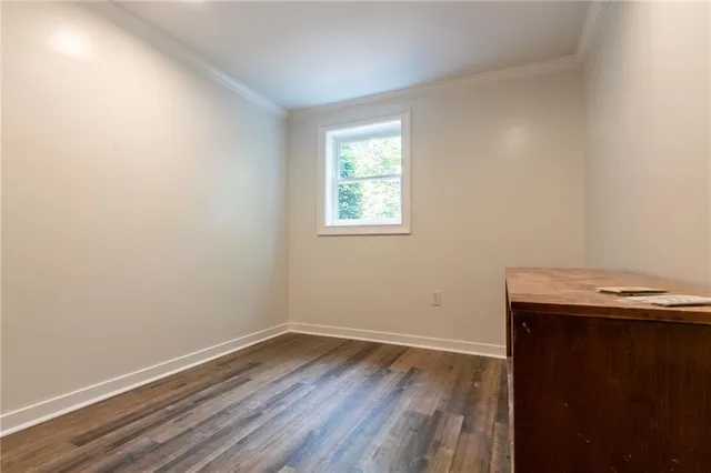 an empty room with wooden floor and window