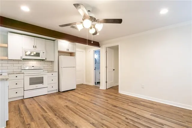 a kitchen with stainless steel appliances a stove top oven cabinets a refrigerator and a window