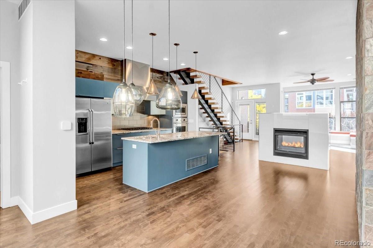 2900 Inca Street, Unit 15 Denver, CO 80202 - Photo 14 of 40 a kitchen with stainless steel appliances a refrigerator and a fireplace