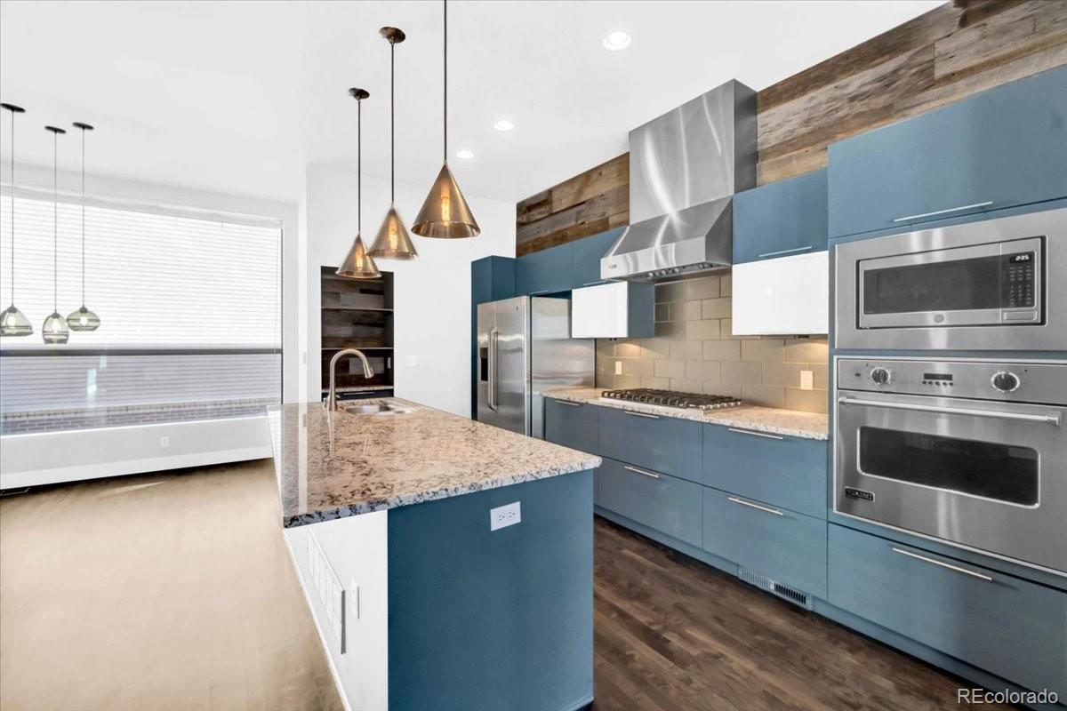 2900 Inca Street, Unit 15 Denver, CO 80202 - Photo 17 of 40 a kitchen with stainless steel appliances kitchen island granite countertop a stove a sink and a microwave