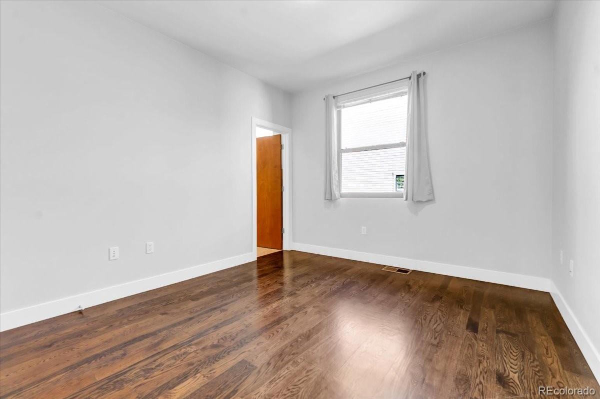 2900 Inca Street, Unit 15 Denver, CO 80202 - Photo 29 of 40 an empty room with wooden floor and windows