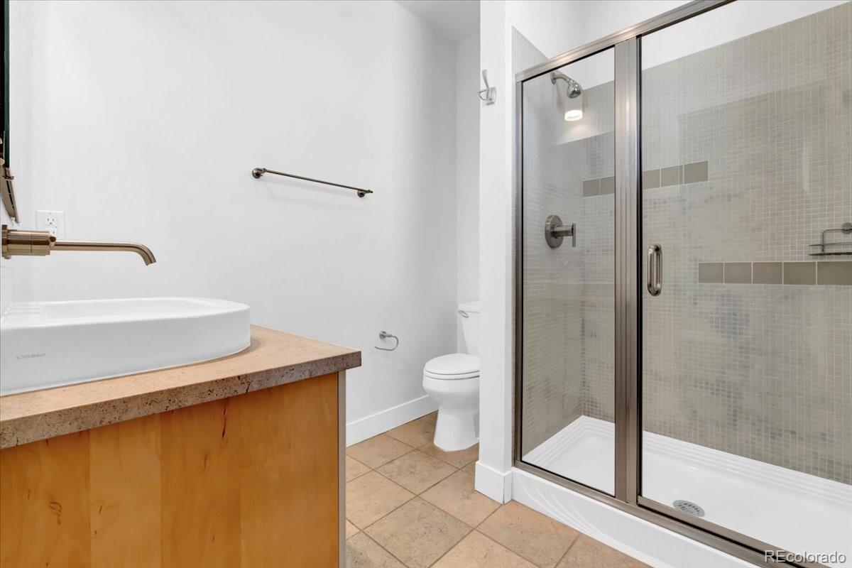 2900 Inca Street, Unit 15 Denver, CO 80202 - Photo 30 of 40 a bathroom with a granite countertop sink mirror and toilet