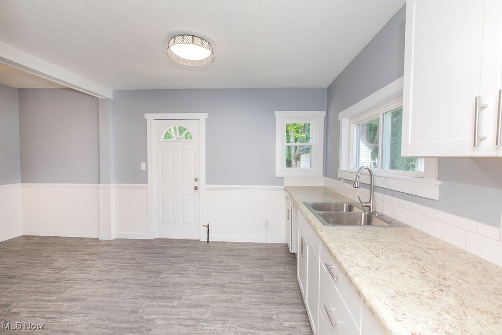 126 River Road Lodi, OH 44254 - Photo 2 of 9 Kitchen with sink, light hardwood / wood-style flooring, and white cabinetry