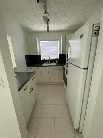 a kitchen with stainless steel appliances a refrigerator sink and microwave