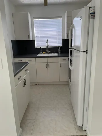 a kitchen with a refrigerator and a sink