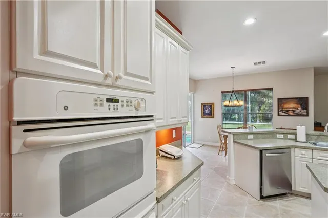 a kitchen with stainless steel appliances a stove a sink and white cabinets