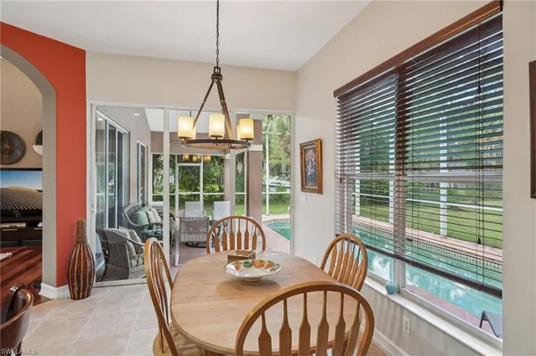 a living room with furniture a flat screen tv and a floor to ceiling window